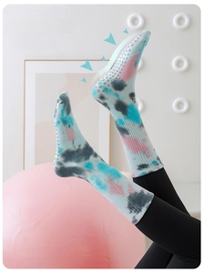 Detail view of tie-dye yoga socks with non-slip silicone grip dots on the sole