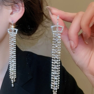 Detail of silver crown earrings with long rhinestone tassels worn for wedding occasions