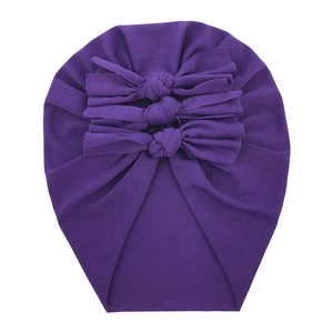 Detail of soft purple cotton baby turban hat featuring three decorative ribbon bows