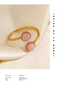 Macro shot of gold plated open ring with pink natural stones on silk fabric