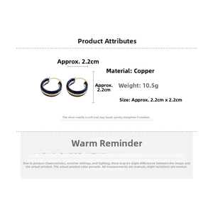 Detail view of gold hoop earrings with navy blue enamel, 2.2cm size copper base and silver pins