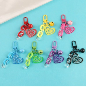 Detail of colorful glitter acrylic heart keychains with metal bells and chains