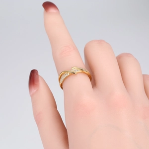Detailed close-up of a crossover gold ring with sparkling white zircon inlays for women