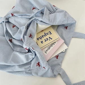 Close-up of large canvas tote bag showing red bow embroidery and striped pattern