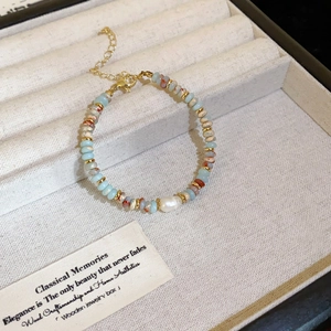 Detail of beaded gemstone bracelet with baroque pearl and golden clasp in jewelry box