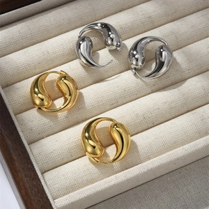 Detailansicht goldener und silberner Tropfenohrringe in einer Premium-Schmuckschatulle
