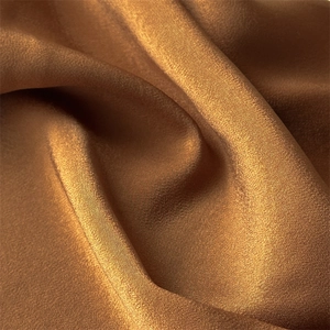 Close-up of glossy brown satin fabric showing delicate texture and soft drapery