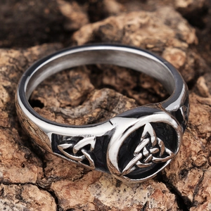 Macro detail of vintage Viking Triquetra ring with oxidized silver finish on rustic wood