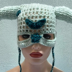 Close-up of light green crochet demon horn hat featuring dark green star and moon embroidery