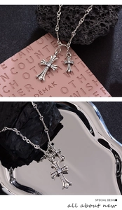 Detail of silver double cross pendant necklace with zircon inlay and rope chain