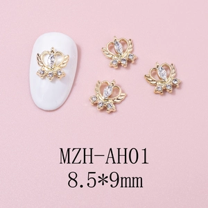 Detailed view of winged heart crown nail charm with zircon inlay in gold finish