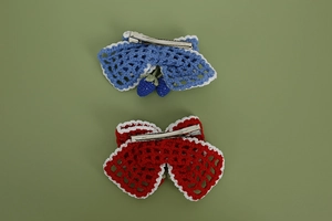 Detail of handmade crochet strawberry bow hair clips with intricate mesh textures