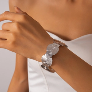 Detailed view of silver layered geometric discs with concentric circular texture on cuff