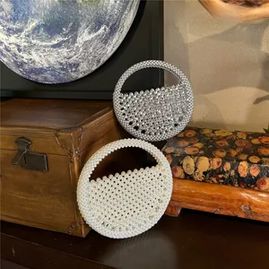 Detail of silver crystal and white pearl beaded half-moon handbags on a vintage background