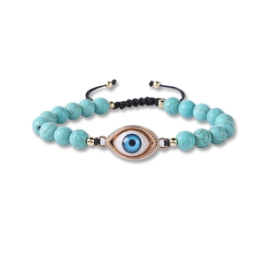 Detailed macro view of woven turquoise bead bracelet with blue evil eye charm