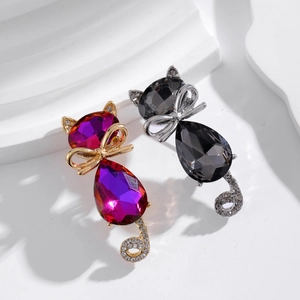 Detailed close-up of cute cat brooches with crystals and delicate bow-knot details