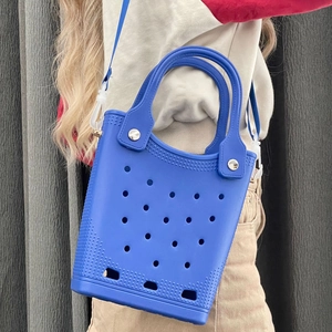 Detail of blue EVA beach bag with holes and silver metal rivets on the handle