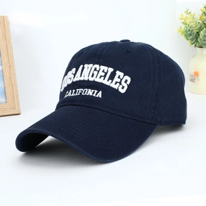 Detail of navy blue cotton baseball cap featuring 3D white embroidered California text