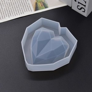 Macro shot of 3D geometric heart silicone mold for resin and soap making on grey base