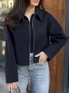Dettaglio di una giacca nera con zip e colletto classico indossata da una modella