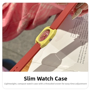 Close-up of slim lemon yellow square watch with red silicone strap and textured crown