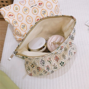 Floral canvas makeup bag with large opening showing cosmetics storage capacity