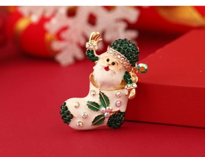 Macro shot of an enameled Santa Claus brooch with green and white rhinestones decoration