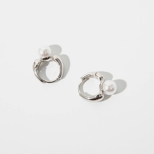 Macro shot of silver pearl hoop earrings with polished finish and glossy round white pearls