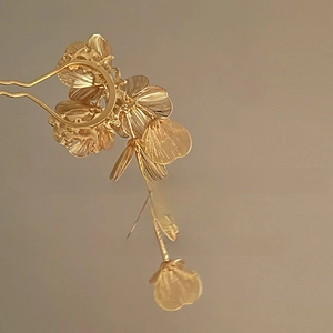 Vue macro d'une épingle à cheveux fleur dorée avec pendentif givré et monture en U