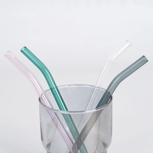 Set of four colorful bent glass straws in pink, green, clear and gray on white background