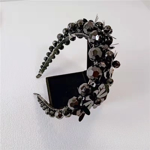 Detailed view of the black beaded headband with intricate floral bow decorations
