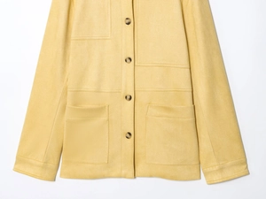Close-up of a bright yellow faux suede shirt jacket with dark buttons and patch pockets