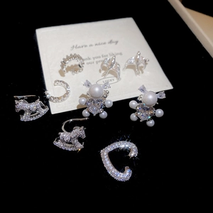 Detailed macro view of S925 silver ear cuffs with zircon and pearl on black velvet