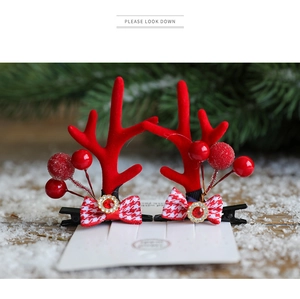 Detail of Christmas reindeer antler hair clips with red berries and houndstooth bows