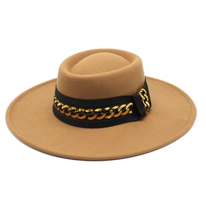 Detail of camel wool fedora hat featuring a stylish black band and gold chain link accent