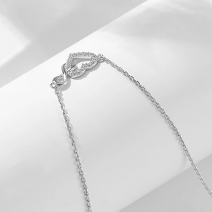 Detailed close-up of sterling silver infinity heart pendant with sparkling crystals