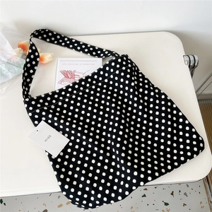 Macro view of black and white polka dot canvas tote bag with a white MISS brand tag