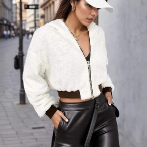 Close-up of white plush hooded jacket with zipper detail and soft furry texture