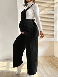 Side view of black corduroy maternity overalls with adjustable waist for pregnancy comfort