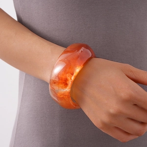 Translucent amber acrylic wide ring bracelet with irregular wave pattern for women