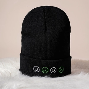 Classic black knitted beanie with four embroidered face emojis on soft winter warm fabric