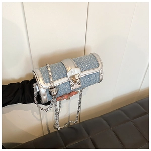 Detail of blue denim barrel bag featuring sparkling sequins and silver metal chain strap