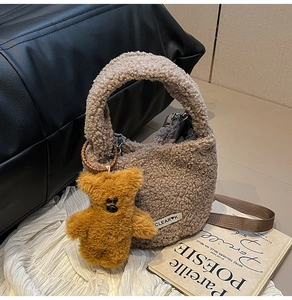Détail du sac seau en polaire douce avec charm d'ours et finitions élégantes