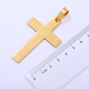 Golden cross pendant with engraved scripture shown next to a ruler for size measurement