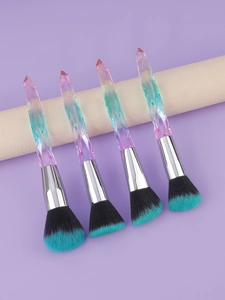 Detail of four colorful crystal handle makeup brushes on a textured white prop