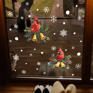 Stickers de Noël avec oiseaux, cloches et flocons de neige sur une porte vitrée