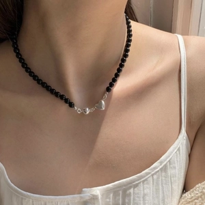 Beaded heart necklace with black pearls and silver magnetic clasp worn by a female model