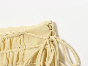 Close-up of the light yellow chiffon fabric with invisible zipper and drawstring details