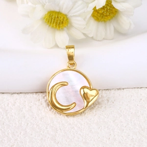 Detail of gold-plated shell heart pendant with moon and heart embossing on white flowers