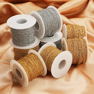 18k gold plated stainless steel cable chains on white spools over gold satin fabric